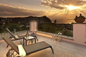 a balcony with a view of the ocean at sunset at Tenuta Del Poggio Antico in Ischia