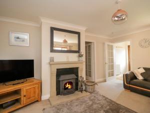 a living room with a fireplace and a television at Cornerways in Kirkby Thore