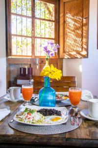 a table with a plate of food and a vase of flowers at Hotel Amor y Paz - Adults Only in Real de Catorce