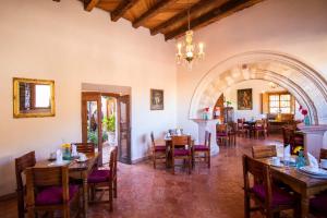 a dining room with tables and chairs and an archway at Hotel Amor y Paz in Real de Catorce