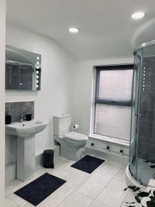 La salle de bains est pourvue de toilettes, d'un lavabo et d'une douche. dans l'établissement Stylish, Spacious & Luxurious Home - Parking, à Liverpool