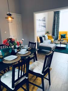 - un salon avec une table, des chaises et un canapé dans l'établissement Stylish, Spacious & Luxurious Home - Parking, à Liverpool