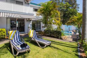 two lounge chairs in the yard of a house at Blueys Motel in Blueys Beach