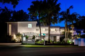 a house at night with palm trees at Blueys Motel in Blueys Beach