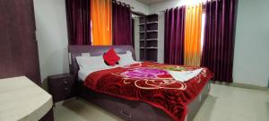 a bedroom with a bed with a red blanket at De Sea apartments in Puri +63 photos