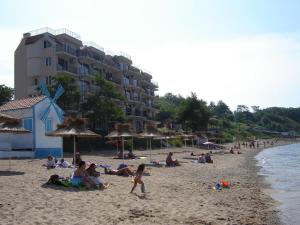 a group of people on a beach with umbrellas at Villa Lazuren Bryag 2 in Chernomorets