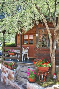 a cabin with a table and flowers in front of it at Camping Alpino - Nature Village in Malcesine