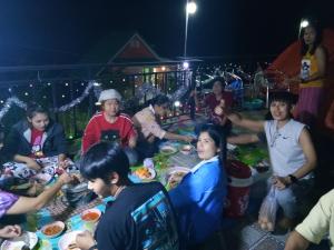 a group of people sitting around a table eating food at ภูร่องลม ฟาร์ม in Phetchabun