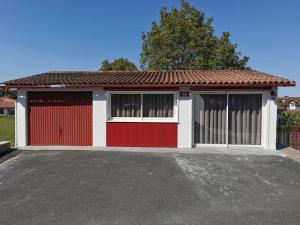 a red and white garage with two windows at Askatasuna in Itxassou