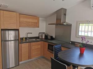 a kitchen with a table and a stainless steel refrigerator at Askatasuna in Itxassou