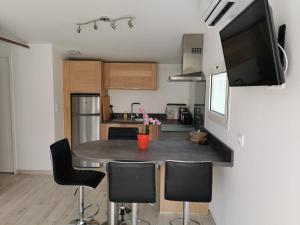 a kitchen with a table with chairs and a tv at Askatasuna in Itxassou +6 photos