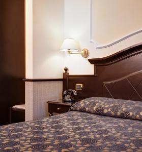 um quarto de hotel com uma cama e um telefone em Hotel Best Roma em Roma