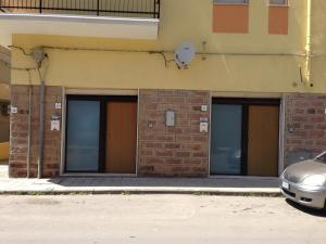 un gruppo di quattro porte del garage su un edificio di Lime Apartments - LIDO ad Alghero