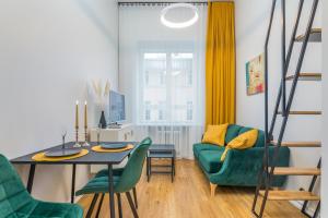 uma sala de estar com uma mesa e cadeiras verdes em Cosy Duo Loft - free GYM em Tartu