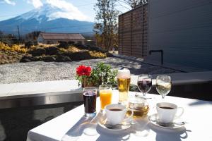 富士河口湖的住宿－Fujikawaguchiko Resort Hotel，阳台上的桌子上摆放着葡萄酒和饮料