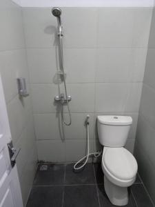 een badkamer met een toilet en een douche bij Guesthouse - Biru Homestay in Tjilimus