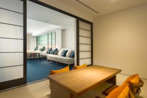 a living room with a table and a couch at Tateshina Grand Hotel Takinoyu in Chino