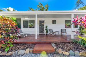 una casa con una terraza de madera frente a ella en BIG4 Whitsundays Tropical Eco Resort, en Airlie Beach