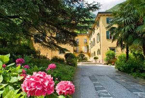 a house with pink flowers on the side of a road at Villa Angelica in Riva del Garda