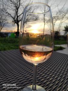 a glass of wine sitting on a table with the sunset at 299 Bigaroux in Saint-Émilion