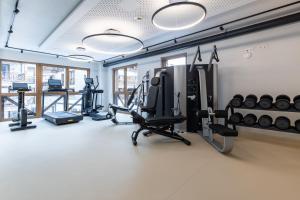 a gym with cardio equipment in a room at Wildkogel Resorts - DAS Neukirchen in Neukirchen am Großvenediger