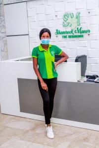 a woman standing in front of a counter wearing a mask at Shamrockmanor(TheResidence) in Benin City