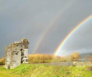 a rainbow over an old building and a tower at Le Soleil Couchant/Chambre d'hôtes in Givet +10 photos