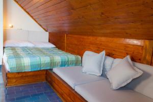 two beds in a room with wooden walls at Apartment Nikola in Makarska