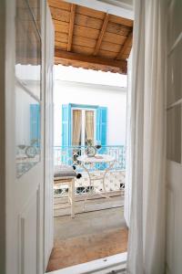 una porta aperta su un balcone con tavolo di Casa Blue Old Port, Philian Collection a Città di Skiathos
