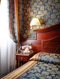 um quarto com uma cama e uma mesa com um candeeiro em Hotel Best Roma em Roma