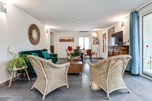 uma sala de estar com cadeiras de vime e um sofá em Villa de 3 chambres avec piscine privee jardin clos et wifi a Beaumes de Venise em Beaumes-de-Venise
