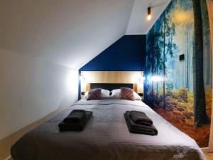 een slaapkamer met een groot bed met een groot schilderij aan de muur bij Agroturystyka Słoszówka in Duszniki Zdrój
