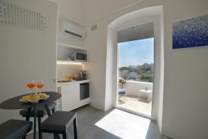 a small kitchen and dining room with a table and a window at Sunshine Luxury Rooms in Ostuni
