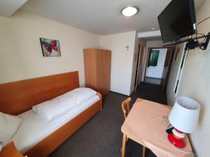 Kleines Zimmer mit einem Bett und einem Tisch in der Unterkunft Gästehaus Ermen in Kamp-Lintfort