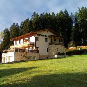 a large house on a grassy field with trees at Transylvania Villa & Spa in Gosau