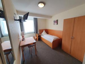 ein Hotelzimmer mit einem Bett und einem Tisch in der Unterkunft Gästehaus Ermen in Kamp-Lintfort