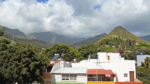 a white building with mountains in the background at Fleitas Penthouse with terrace in San Andrés