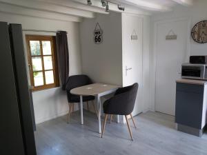 una pequeña cocina con mesa y 2 sillas en La Champêtre, en Beaumesnil