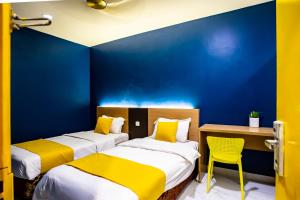 2 camas en una habitación con una pared azul en BEEZ Hotel Kuala Lumpur, en Kuala Lumpur