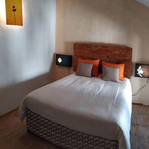 a bedroom with a large white bed with orange pillows at El Asno Azul in Ribera Baja