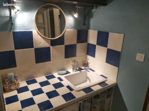 La salle de bains est pourvue d'un lavabo et d'un miroir. dans l'établissement Charmant appartement dans maison de village, à Mesnois