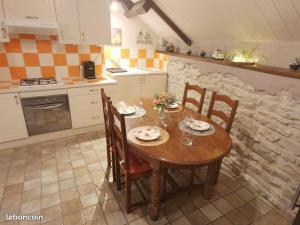 - une cuisine avec une table en bois et des chaises fleuries dans l'établissement Charmant appartement dans maison de village, à Mesnois