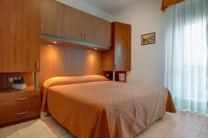ein Schlafzimmer mit einem Bett, einer Kommode und einem Fenster in der Unterkunft Hotel Jalisco in Lido di Jesolo