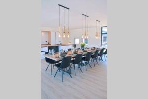 una sala da pranzo e una cucina con un lungo tavolo e sedie di 5-sterren Landhuis met zwembad en jacuzzi a Ypres