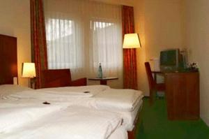 a hotel room with two beds and a television at Hotel Auerhahn in Pulheim