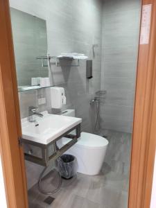 a bathroom with a sink and a toilet and a mirror at 花總管 in Chin-yüan