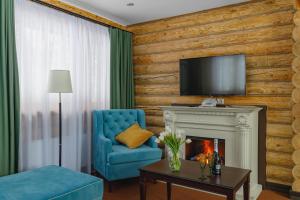 ein Wohnzimmer mit einem blauen Stuhl und einem Kamin in der Unterkunft Istra Holiday Hotel in Trusovo