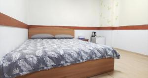 1 dormitorio con 1 cama con cabecero de madera en Healinghouse Peakjang, en Buyeo