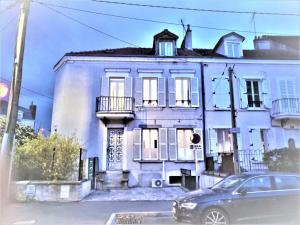 ein weißes Haus mit einem davor geparkten Auto in der Unterkunft APPARTEMENT PROCHE CENTRE VILLE, GARE ET AUTOROUTE in Melun