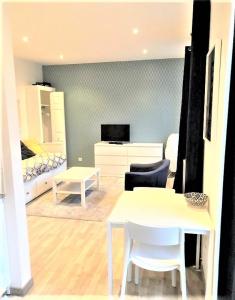 a living room with a table and a bedroom at APPARTEMENT PROCHE CENTRE VILLE, GARE ET AUTOROUTE in Melun